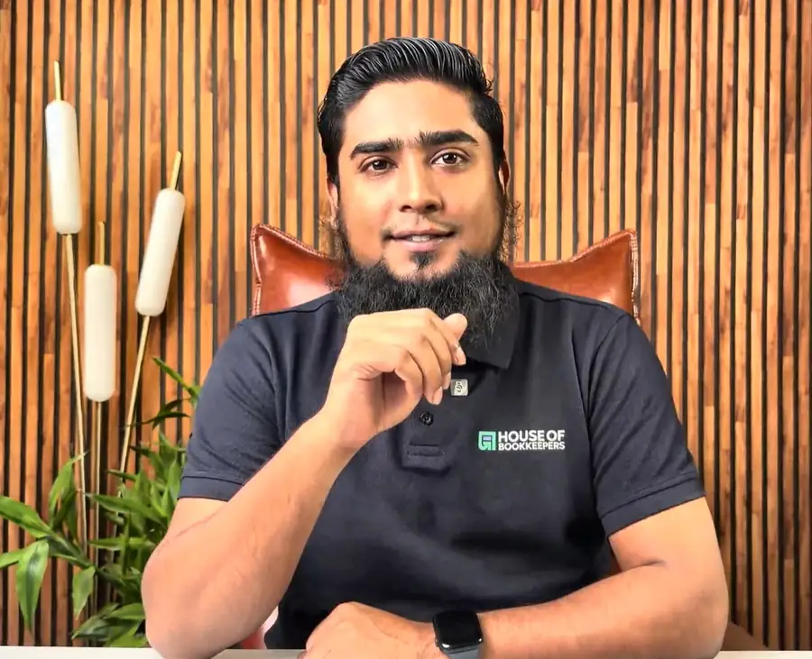 Mehedi at his desk in a House of Bookkeepers shirt